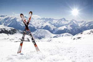 Skis plantés dans la neige aux Karellis avec vue sur les montagnes pour apprendre à skier en Savoie