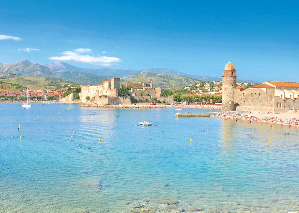 Collioure en Occitanie avec plage, château royal et clocher au bord de la mer