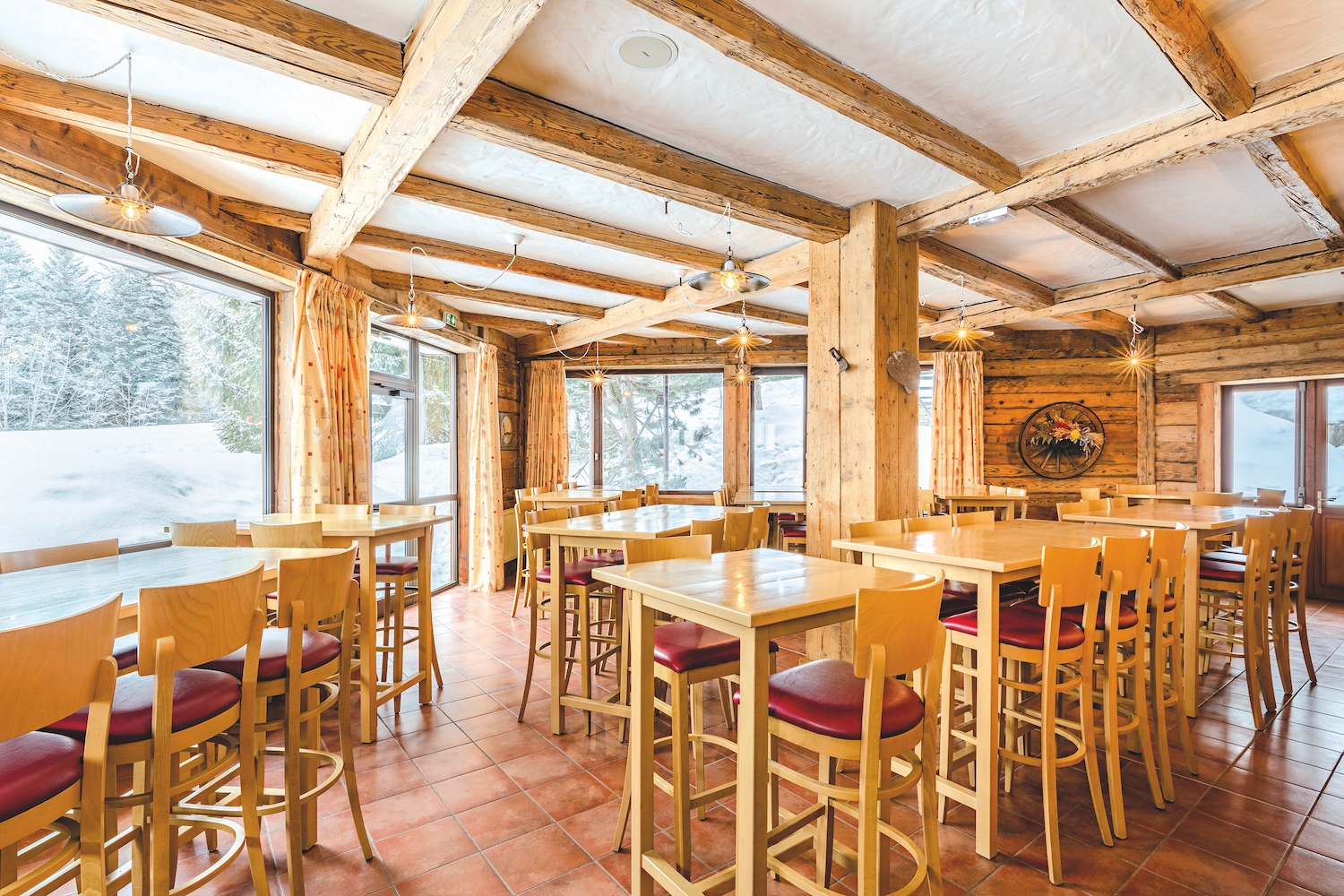Salle de restaurant chaleureuse en chalet aux Karellis avec vue sur la neige