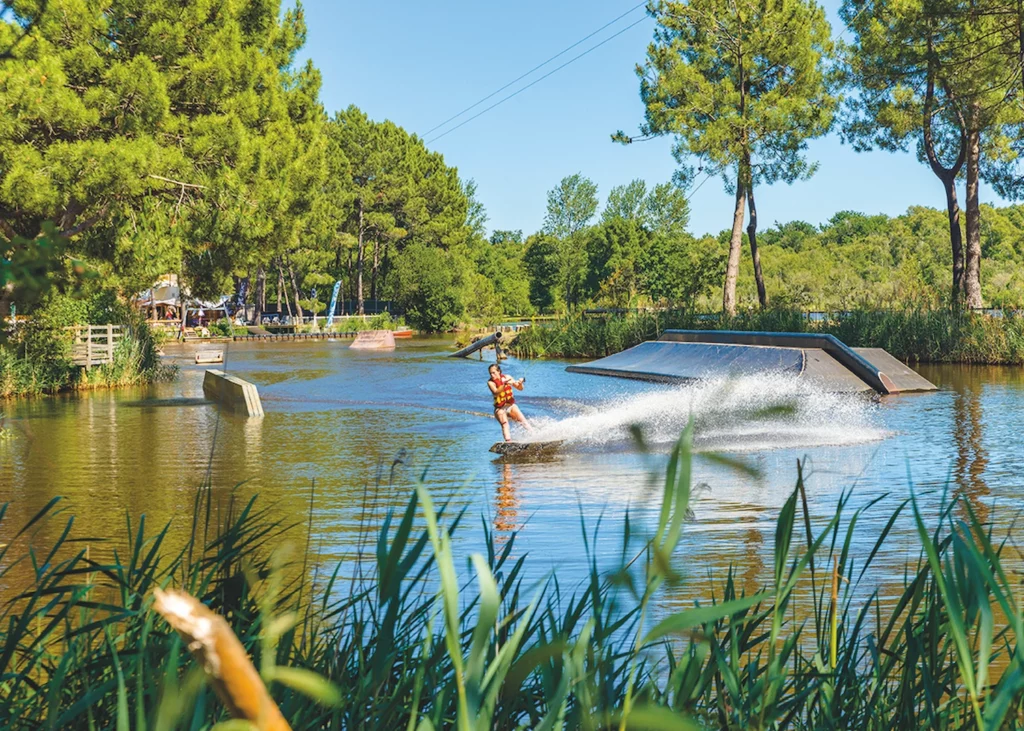 Wakeboard sur plan d’eau à Lacanau dans un environnement naturel pour apprendre le surf