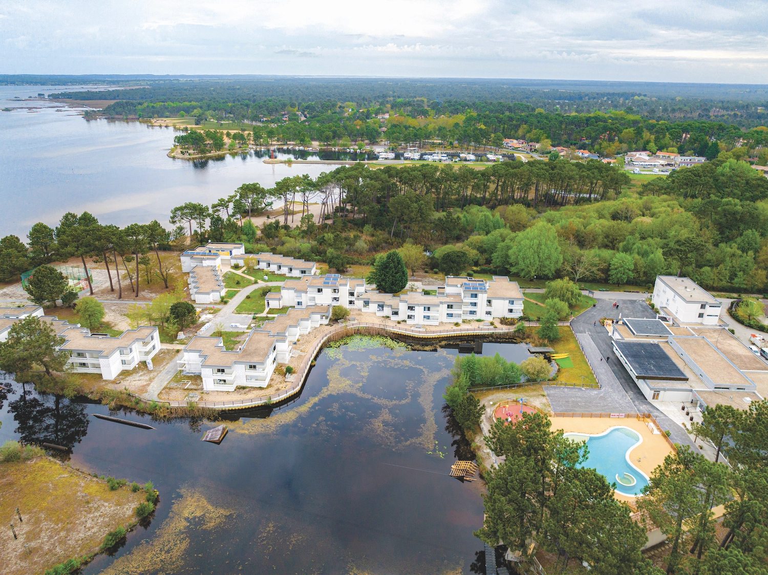 Vue aérienne du village vacances Azureva Lacanau avec lac, forêt et piscine