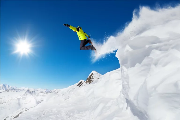 Snowboardeur en saut dans la poudreuse à La Clusaz dans les Alpes pour un séjour ski freestyle