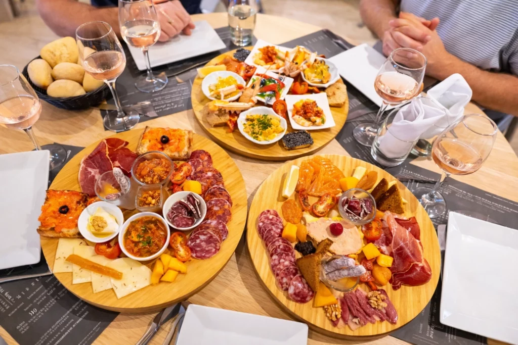 Planches de charcuterie et fromages français accompagnées de vin rosé lors d'un apéritif convivial