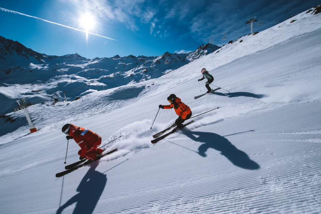 Famille skiant sur une piste enneigée dans les Alpes en hiver